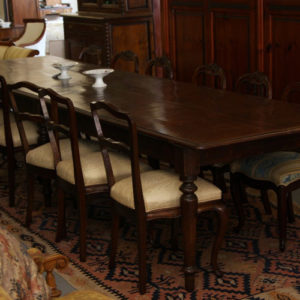 Art.TP.1 - Importante tavolo da pranzo/riunione, interamente in legno di noce con piano lastronato noce a riquadri geometrici, sei gambe tornite.